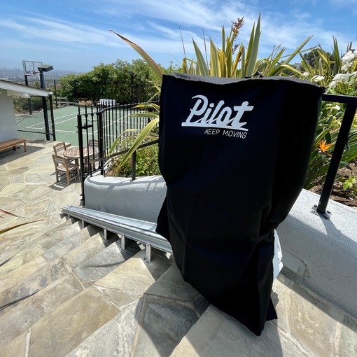 Outdoor stair lift with protective rain cover.